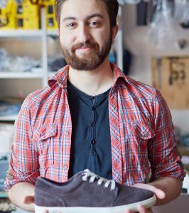 Portrait of a handsome man selling footwear in sports shop